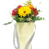 A pale yellow gift bag with silver ribbon handles holds a mixed floral arrangement: a bright yellow gerbera daisy at center, surrounded by orange rose buds, red alstroemeria, small pink blooms, white waxflowers, and assorted fern and eucalyptus foliage.