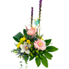 Two tall purple liatris stems rise above a mix of yellow blooms, a pink gerbera, and a white orchid nestled in green foliage. Small baby clothes (a pink gingham skirt, polka-dot romper, and tiny sneakers) hang on twine strung between the liatris stalks.