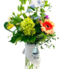 A tall, clear glass cylinder vase partially filled with pebbles holds a celebratory mixed bouquet. Fern fronds, eucalyptus, and variegated palm leaves form a lush green backdrop. A cluster of bright chartreuse hydrangea sits at center, alongside an orange-pink gerbera daisy and yellow alstroemeria blooms. Sprays of tiny blue forget-me-nots and purple liatris spikes rise above, with trailing ivy vines weaving through the greenery. Draped around the vase’s neck is a gray bib printed with a sailboat graphic and the words “Little Captain.” At the very top, a pair of white baby socks with light blue accents and star patterns are tucked among the stems, creating a whimsical, new-baby accent.